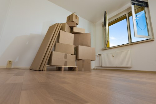 Movers carrying boxes through a West London apartment building