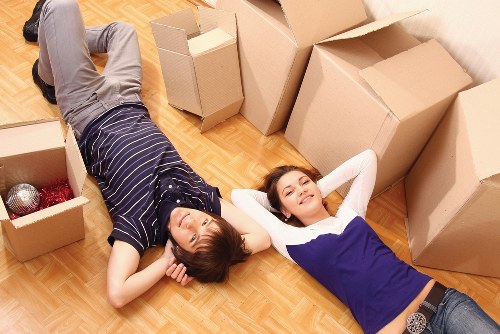 Movers using correct lifting methods with furniture and boxes