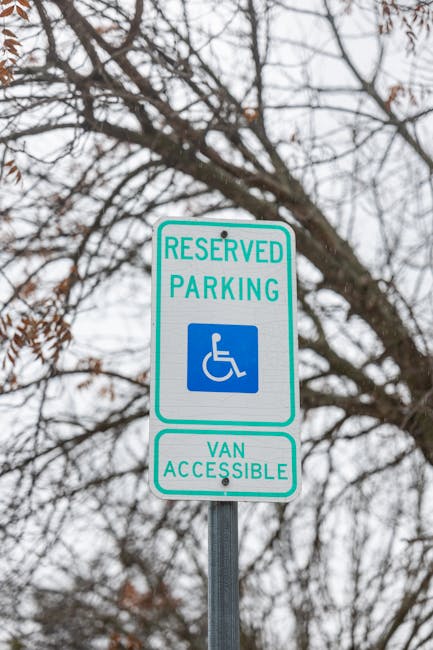 Four parking permit signs with blue backgrounds and white lettering mounted on metal posts are aligned in front of a metallic corrugated wall. The signs display a large letter 'P' indicating parking, 